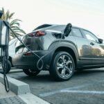 Modern electric vehicle charging at an outdoor station in daylight.