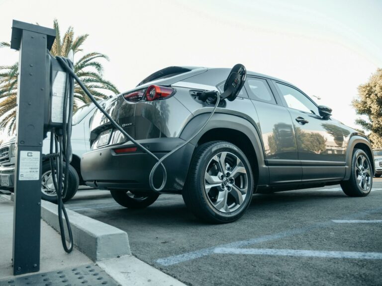Modern electric vehicle charging at an outdoor station in daylight.